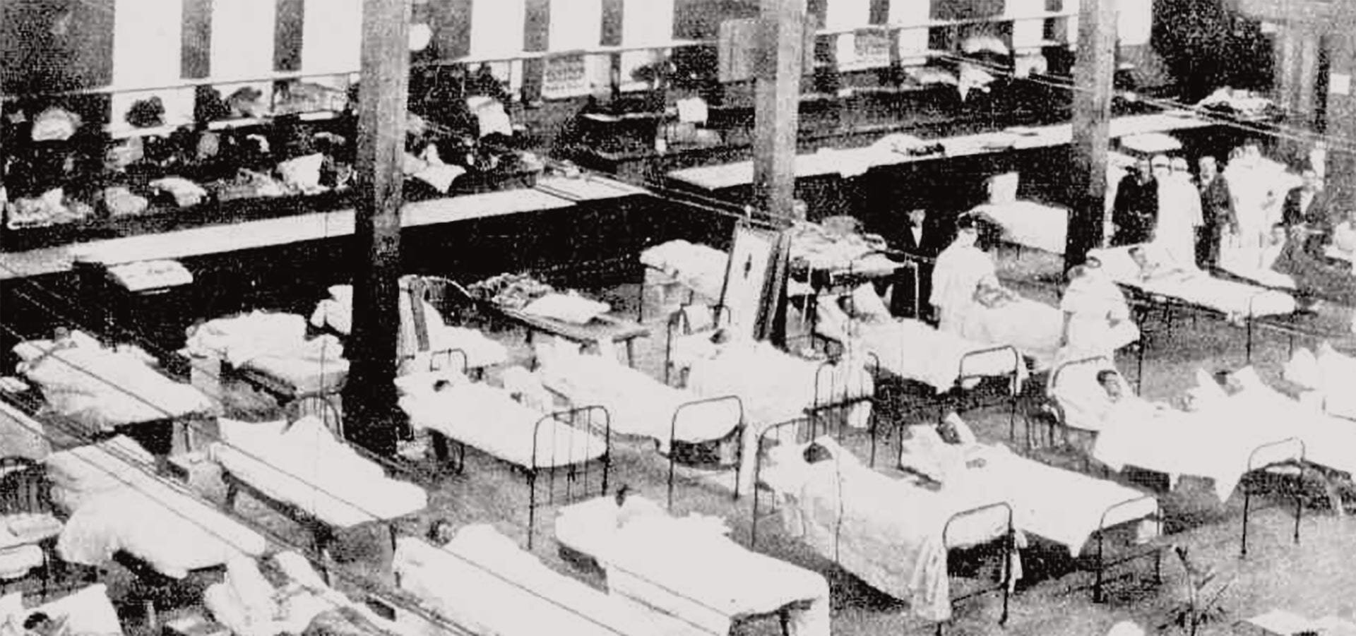 [Image description: rows of hospital beds in a large open space with nurses and other figures walking between them]The Royal Exhibition was converted into a hospital during the 1919 influenza epidemic